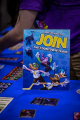 Merchandise and a table sign at the Toontown booth during ToonFest: Birthday Bash.
